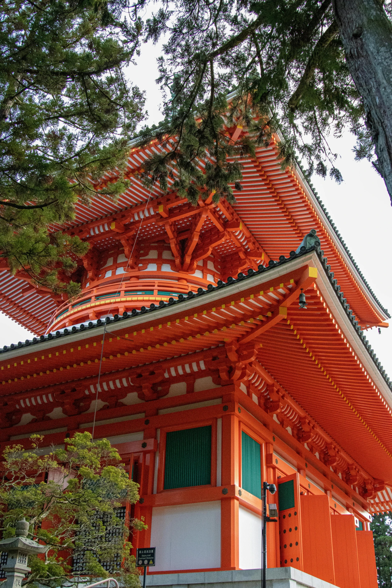 an orange pagoda with a white door next to a tree