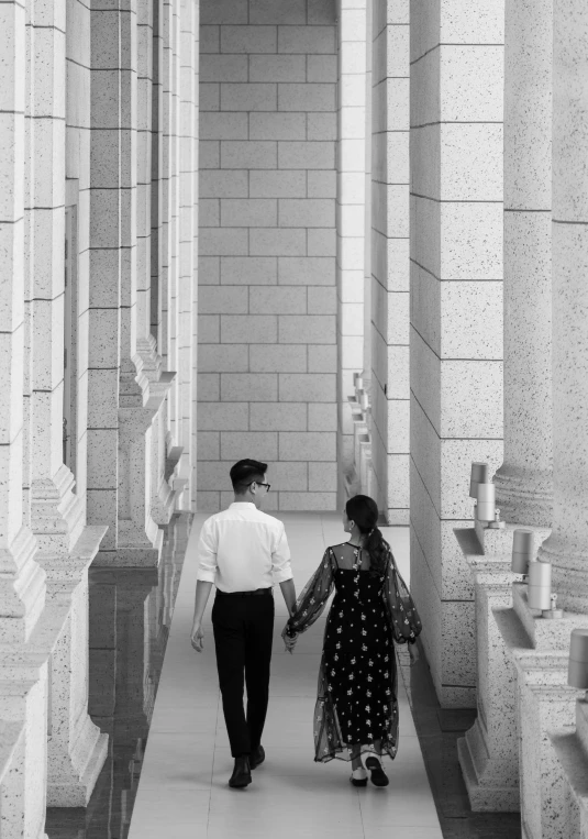 a couple is walking down a long hallway