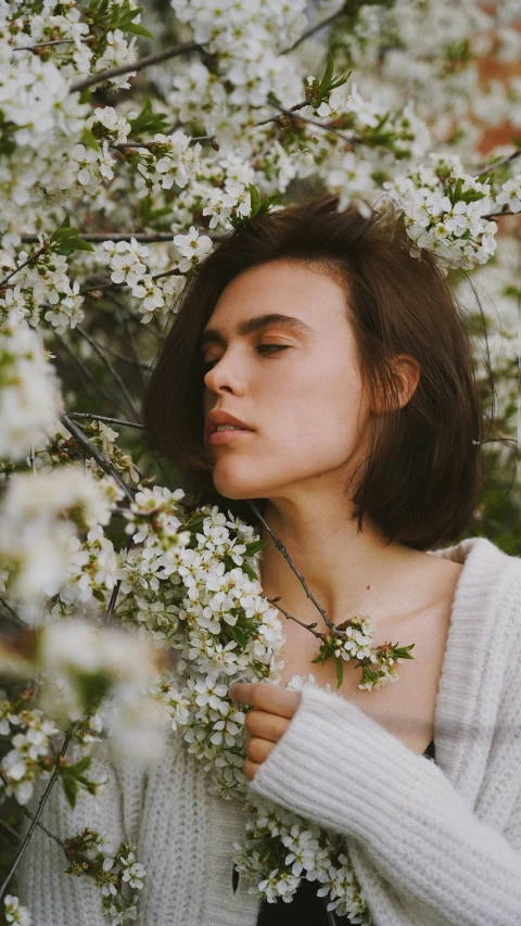 a woman is in a field with blossom