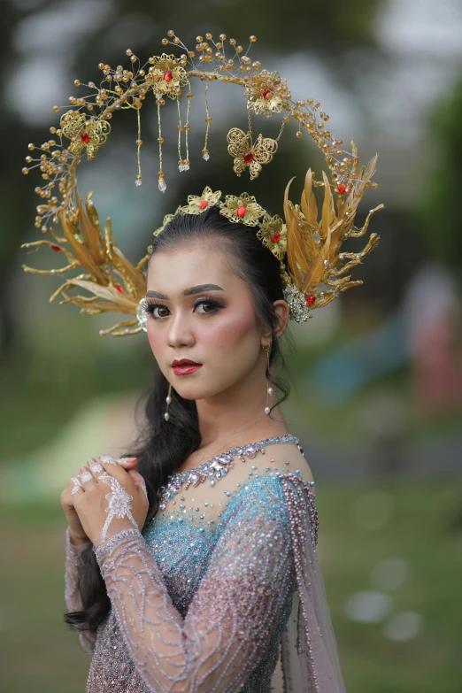 a girl dressed in traditional ethnic clothes with gold leaves on her head