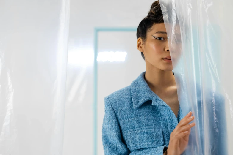 a woman stands next to clear plastic covering her face