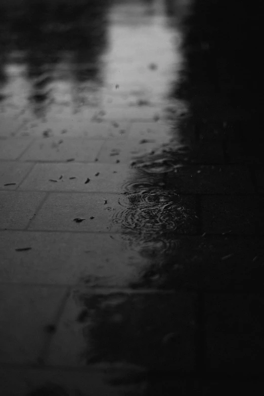 a rainy view of some water, with rain drops and street lights