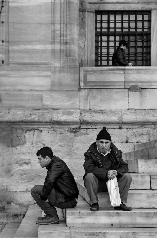 two people sitting on a stone steps together