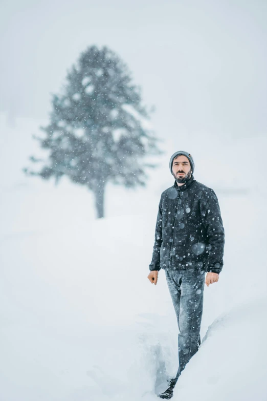 a man is walking through deep snow during the day