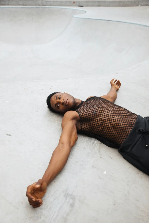 the male skateboarder is dressed in a net top