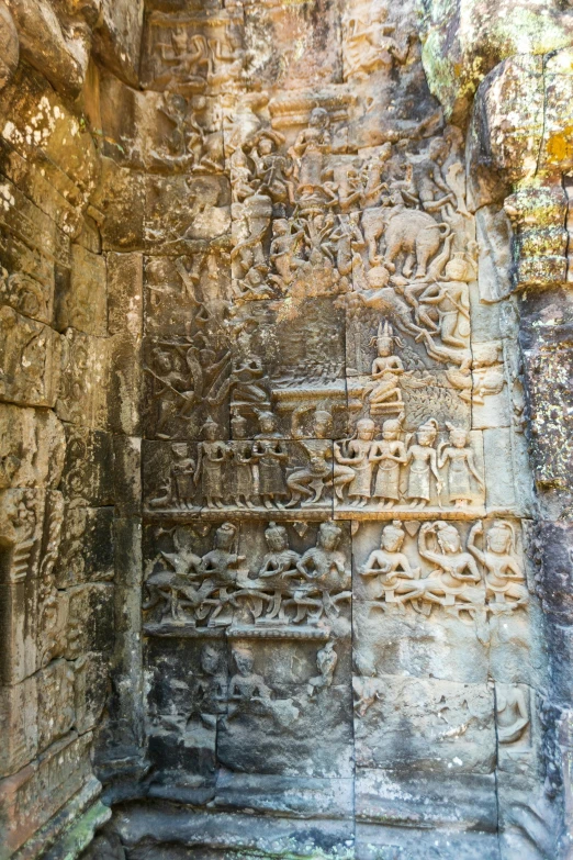 carved designs on stone wall with tree near doorway