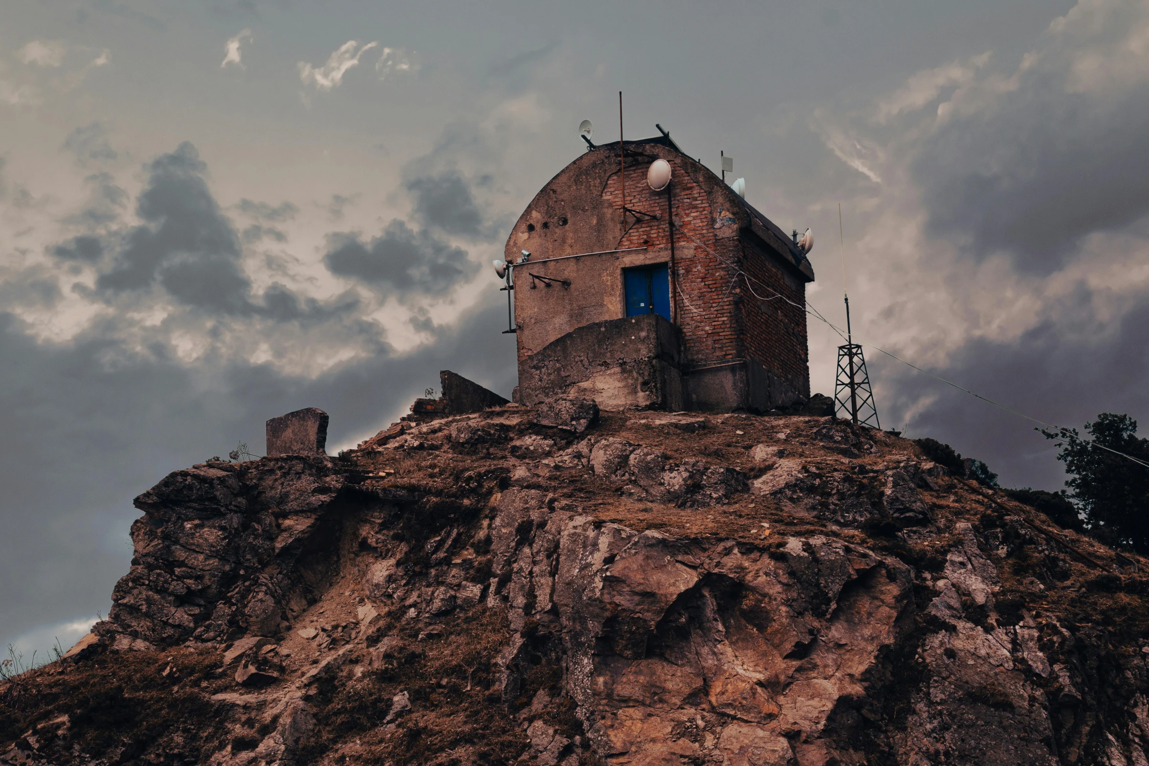 a building sitting on top of a rocky mountain