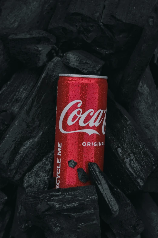 coke can sitting on coal with red and black color