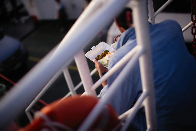 a man with a bunch of food sitting on top of a boat