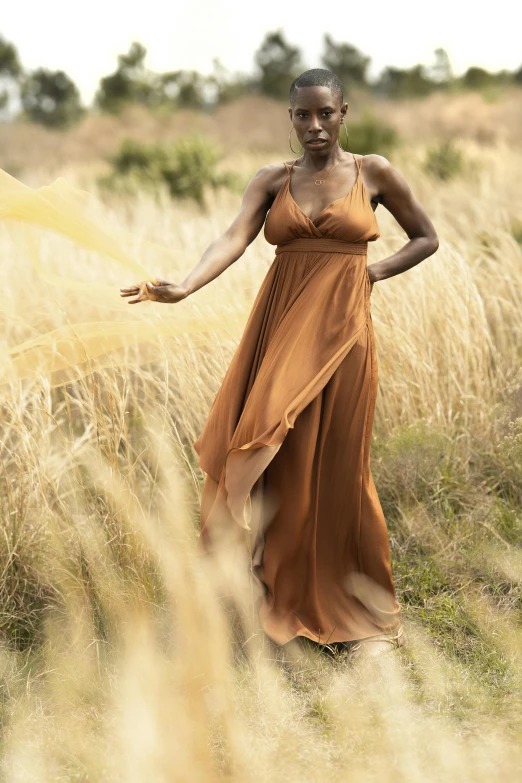 a woman in an orange dress holding out her hand