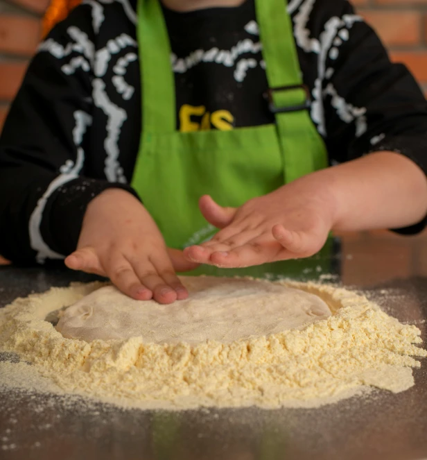 a person making a dough on top of a counter