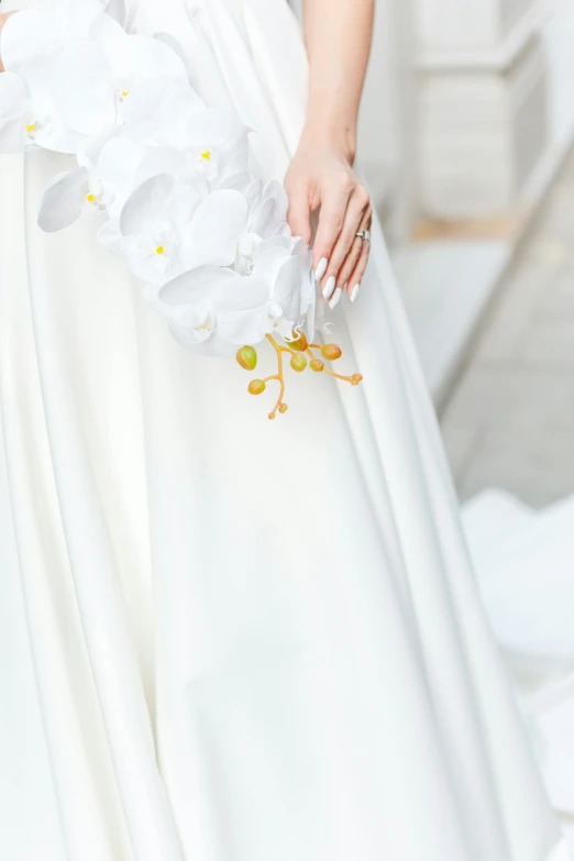 woman wearing dress with flowers in it holding white bouquet