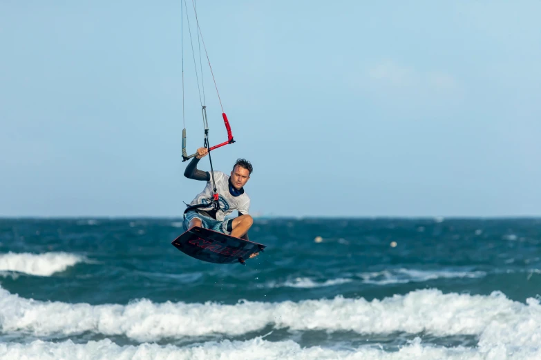 the man is wind surfing on the ocean waves