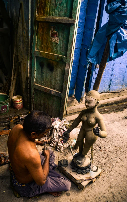 an asian man with his arm around a small statue