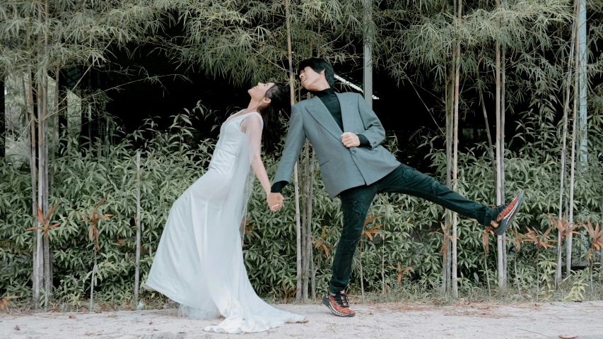 a bride and groom have their legs together as they kick up the air