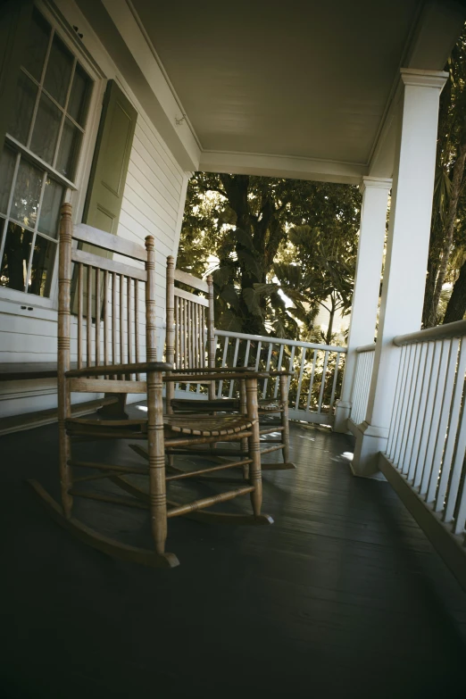 a large rocking chair on a porch in front of a building