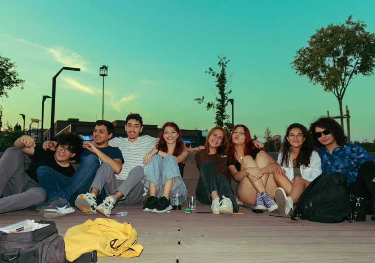 a group of young people are sitting around on the ground