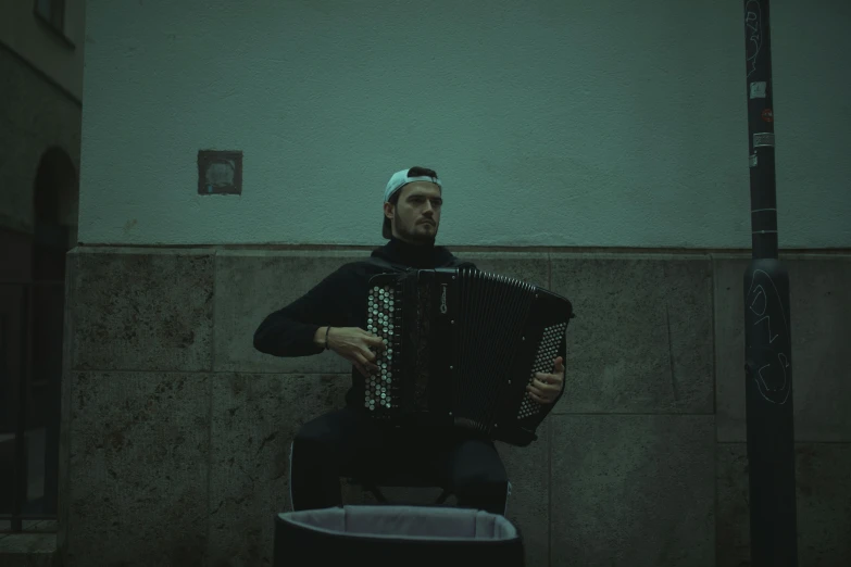 a man playing an accordos in front of a wall