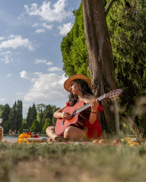 a girl in a red dress is playing the guitar