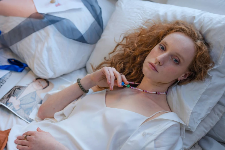 a beautiful young redhead girl lying in a bed