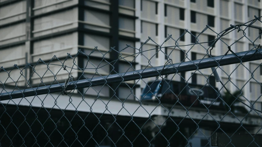 a large building in the back, and a chain link fence around it