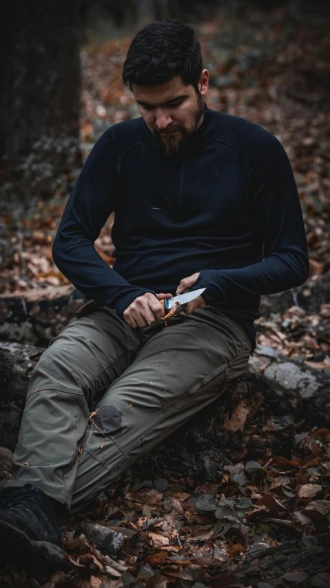 man in a dark suit sitting on the ground holding soing