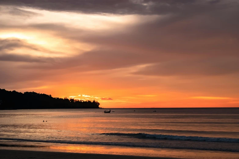 a small boat is out on the water at sunset