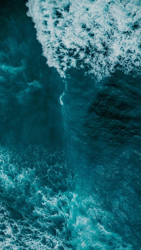 a wave crashing under a large body of water