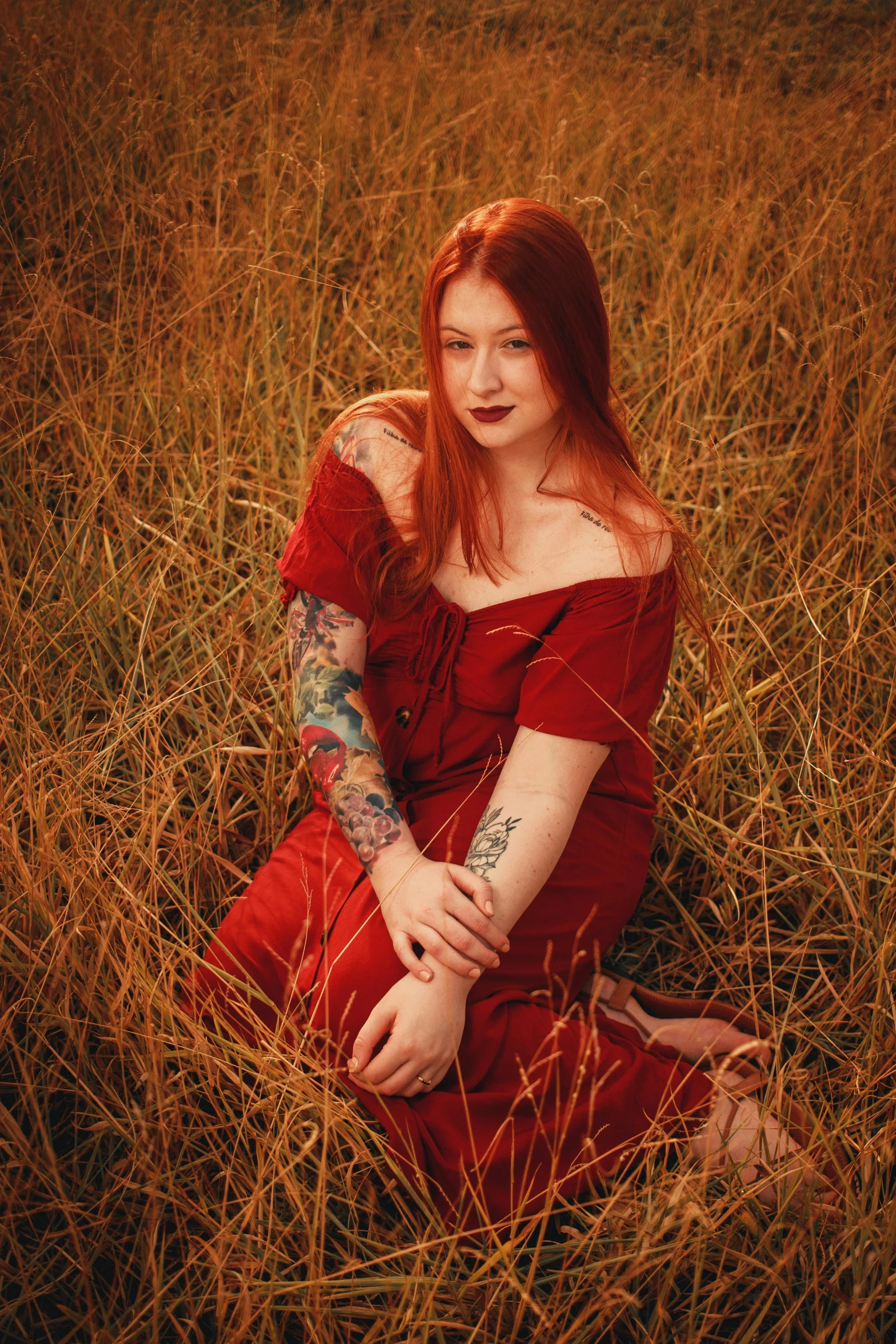 an orange haired woman in red sitting on the ground