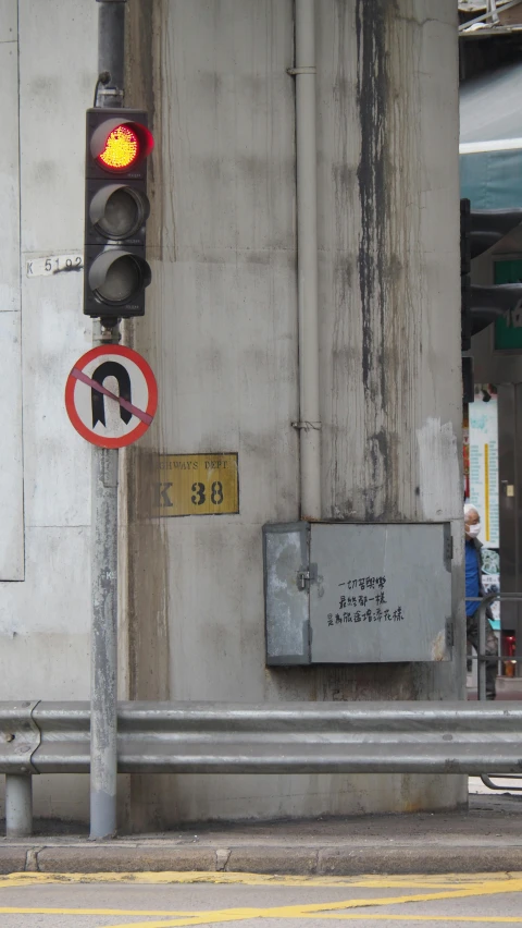 a street sign and traffic light in front of a gray building