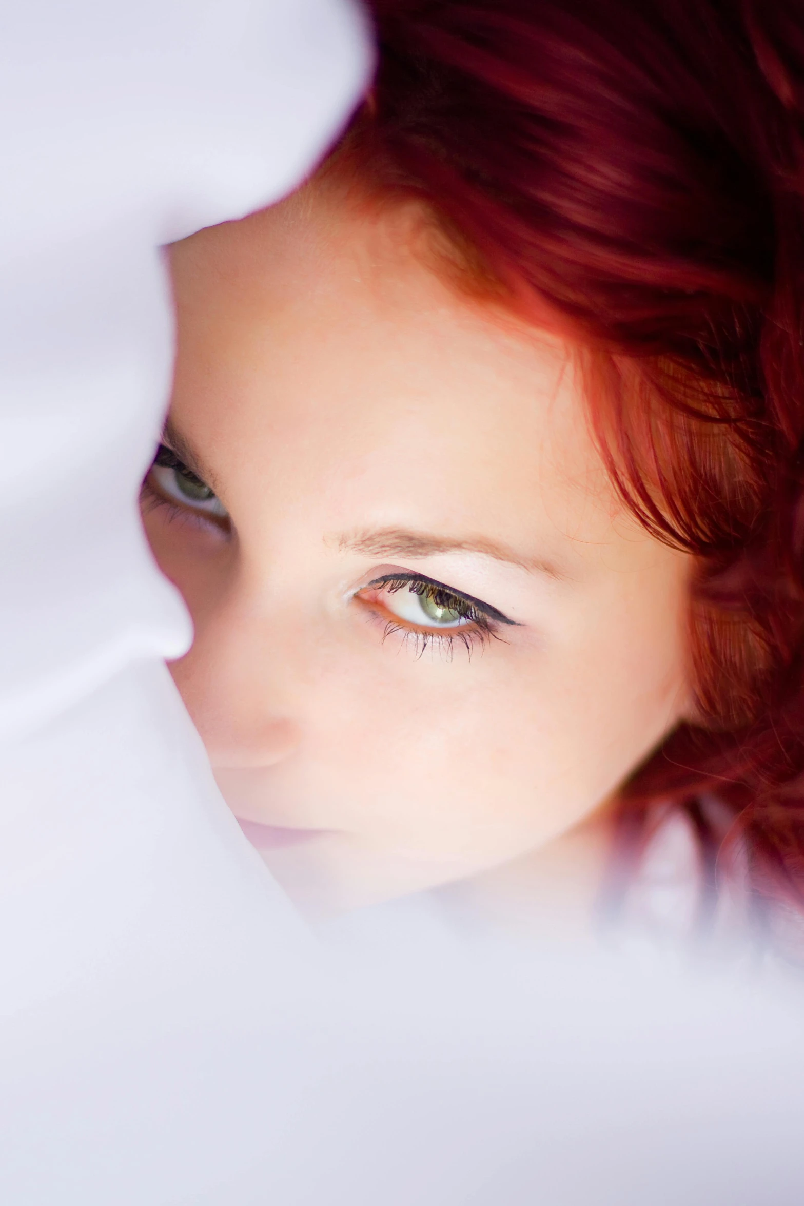 a close - up of a red haired woman wearing blue