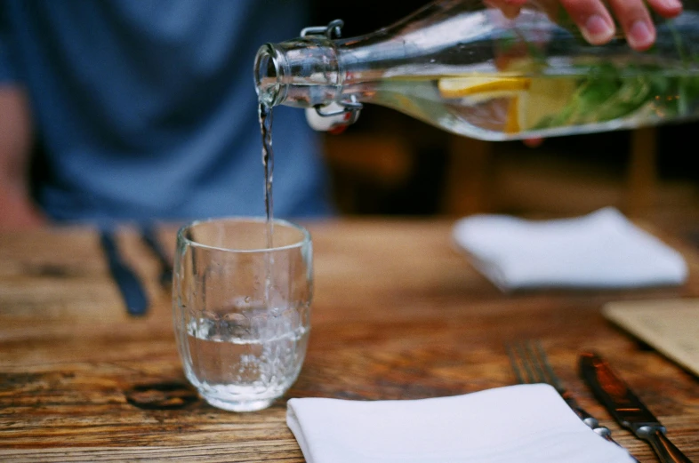 an empty glass and a bottle of water are on the table