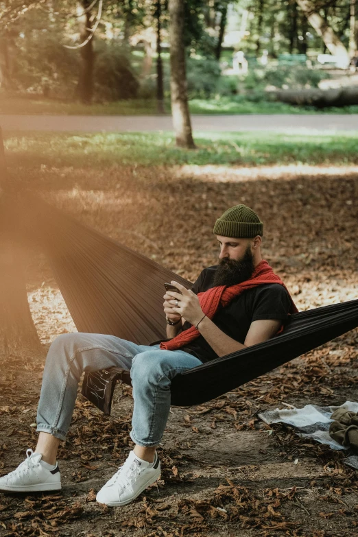 man relaxing in a hammock in a park