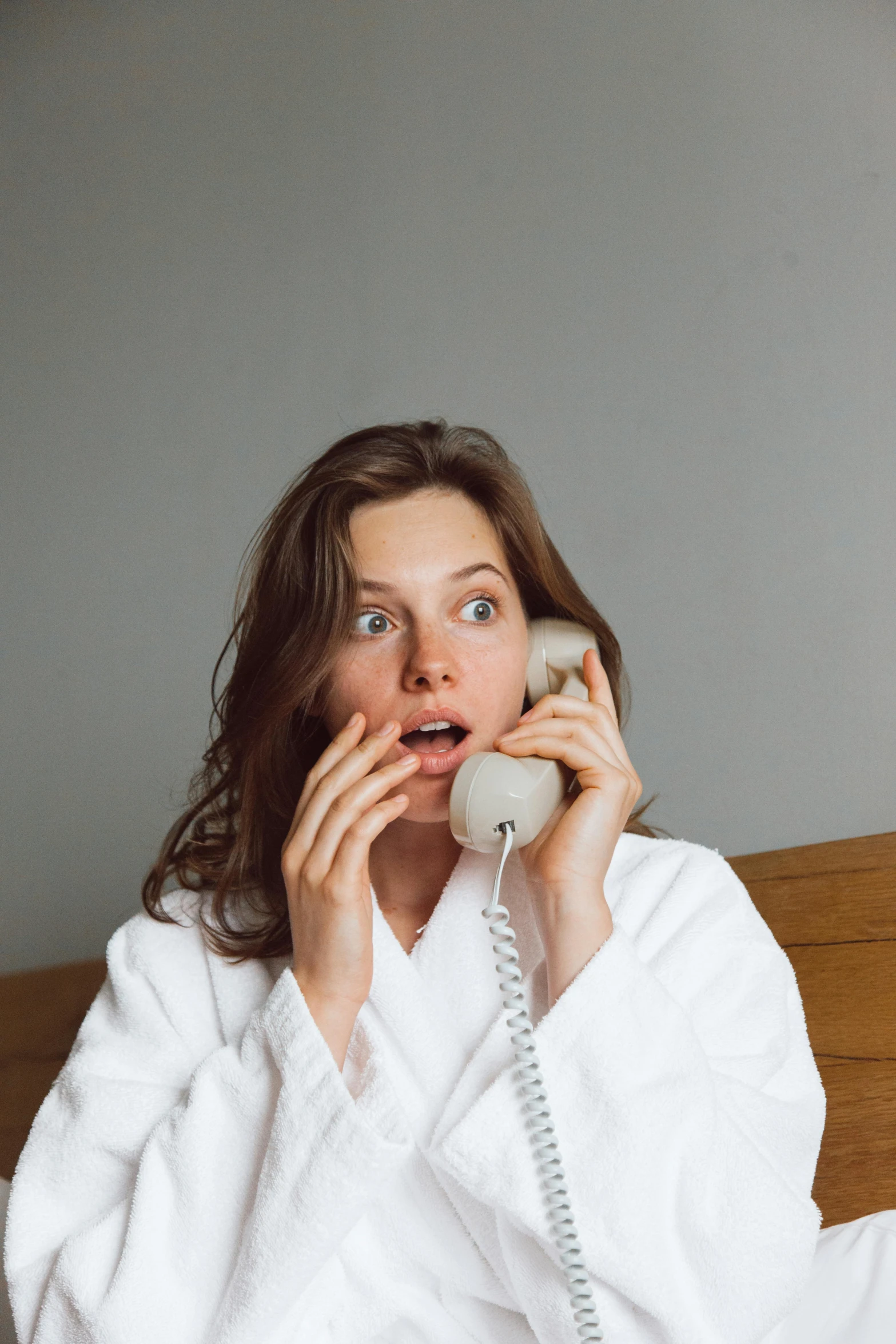 a woman on her bed talking on a phone