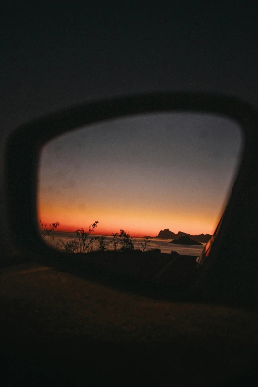 a car mirror looking out into the ocean