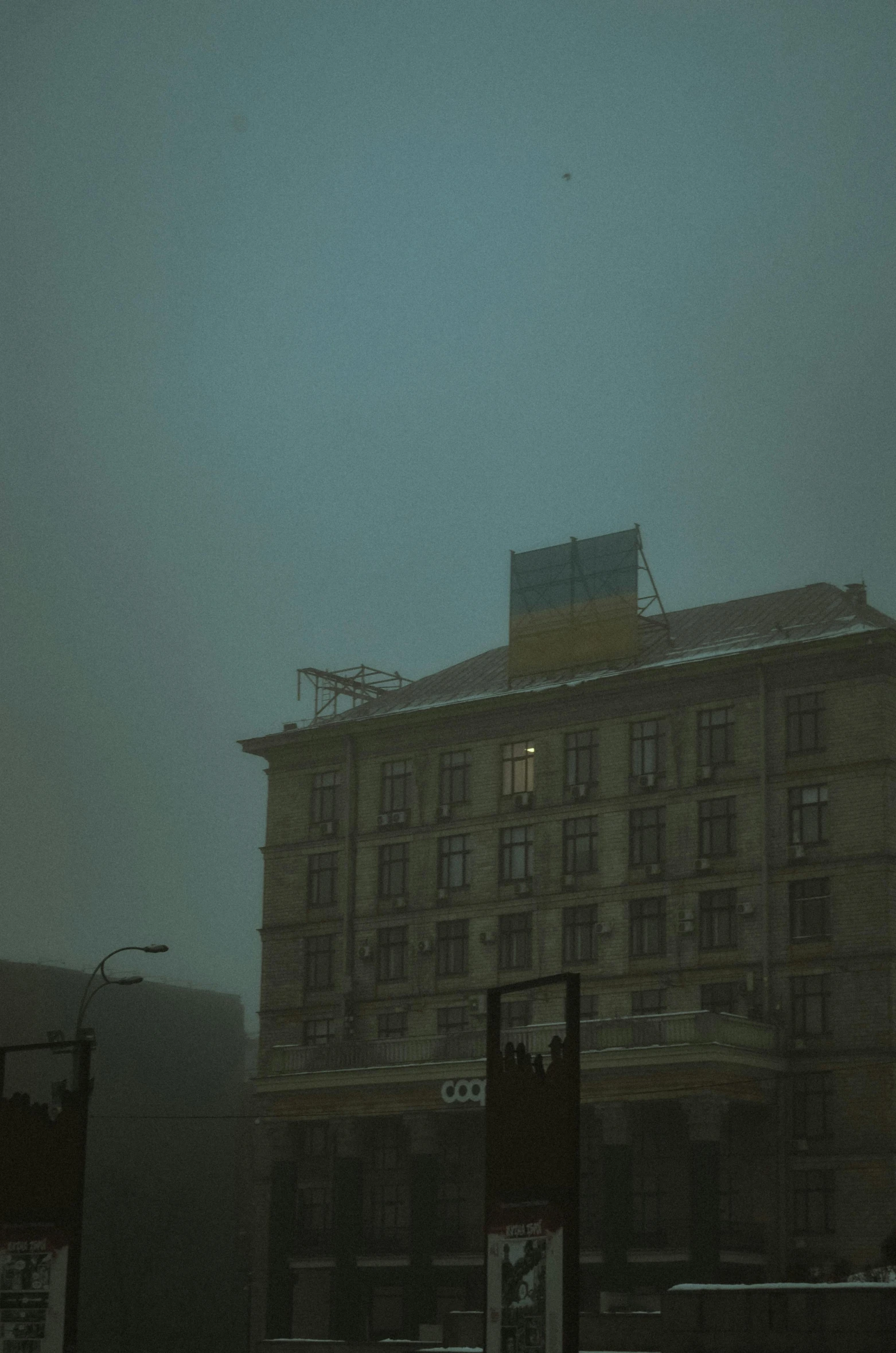 dark picture of an old building with snow on the ground