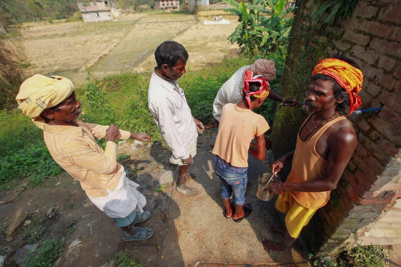 two men and three women talking next to trees