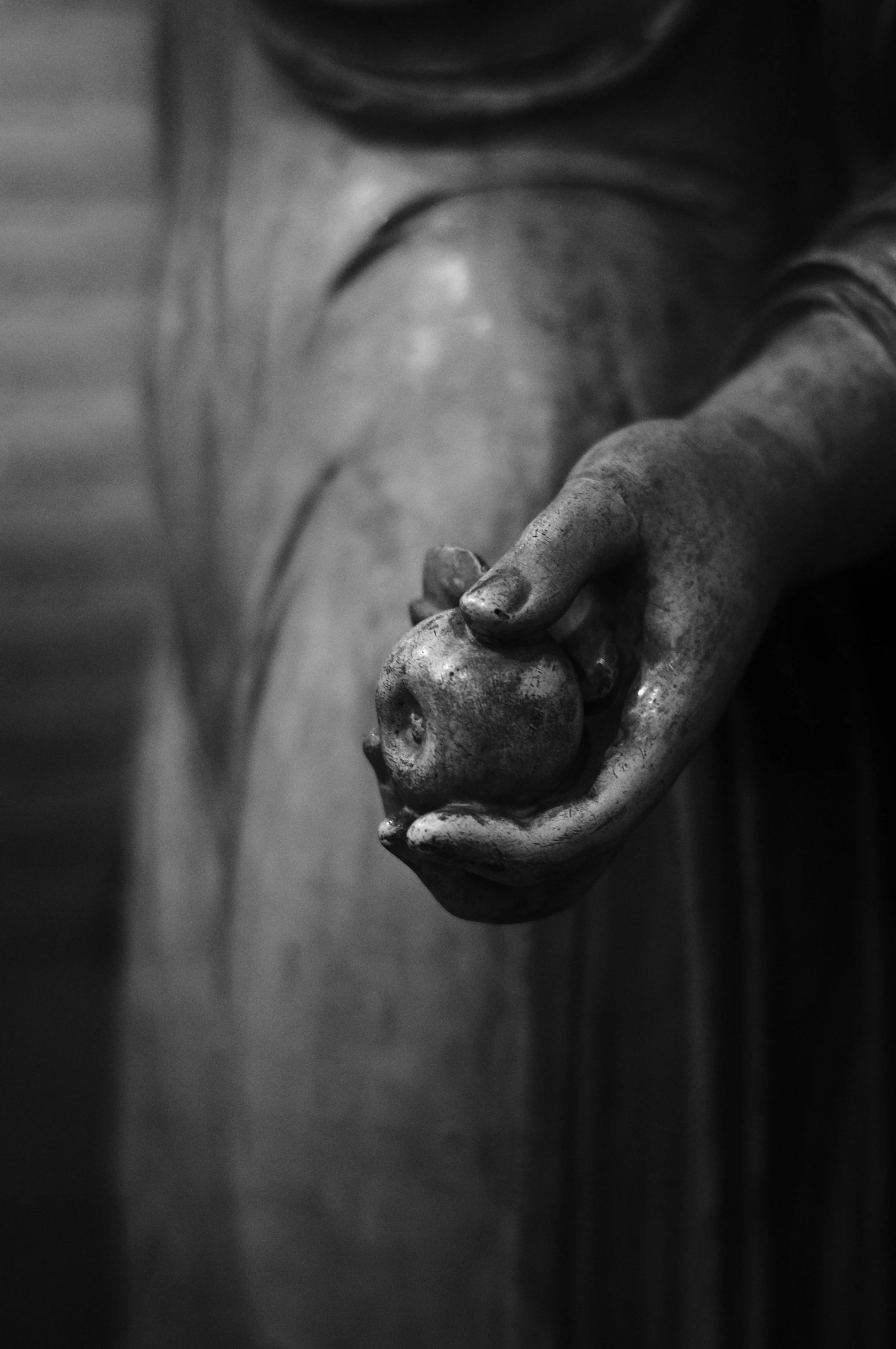 a person with his hands on a statue holding soing