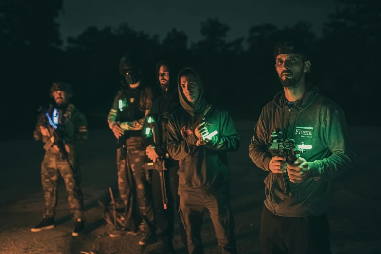 four men and two women standing together outside holding lights