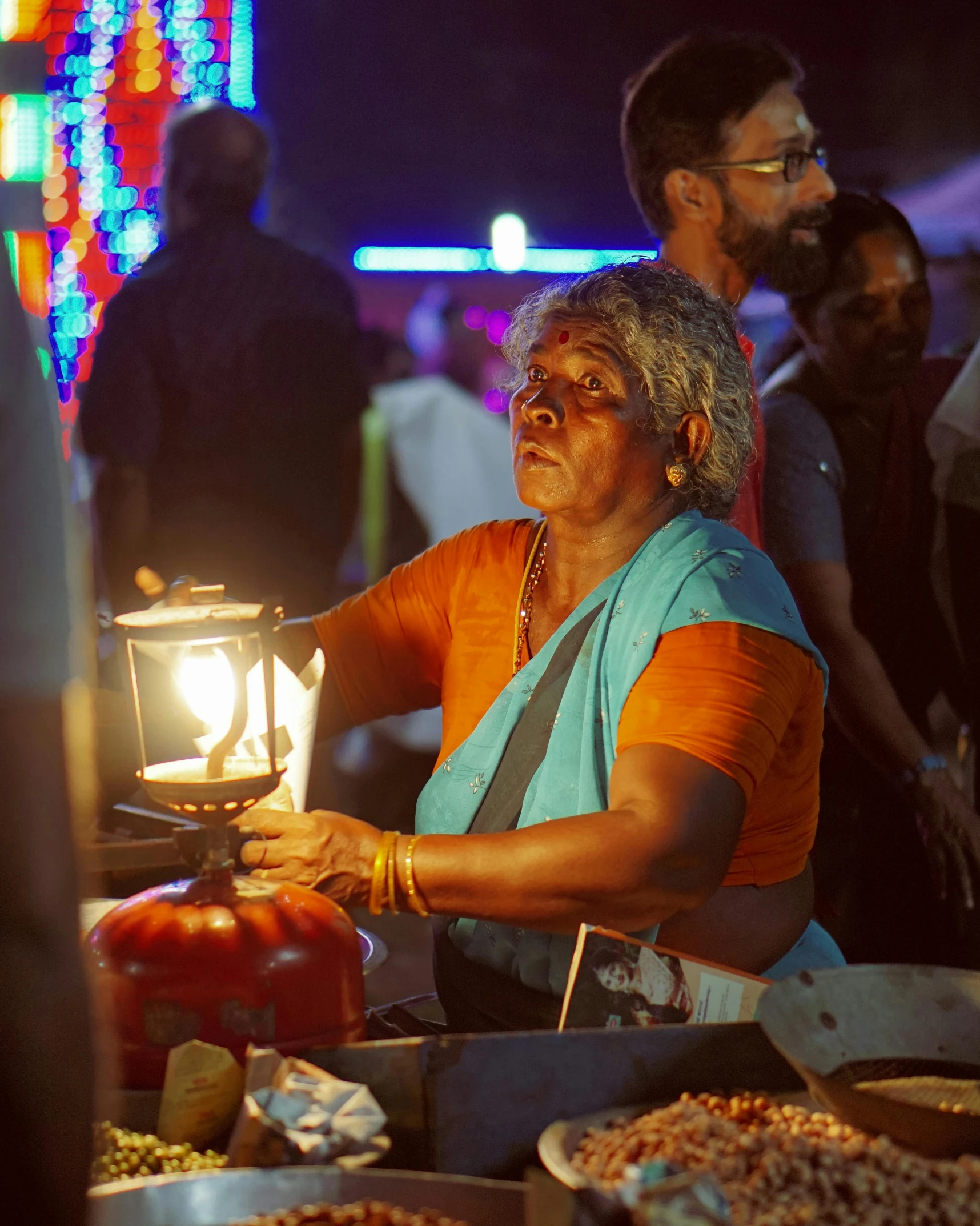 a lady is lighting some kind of lantern at the festival