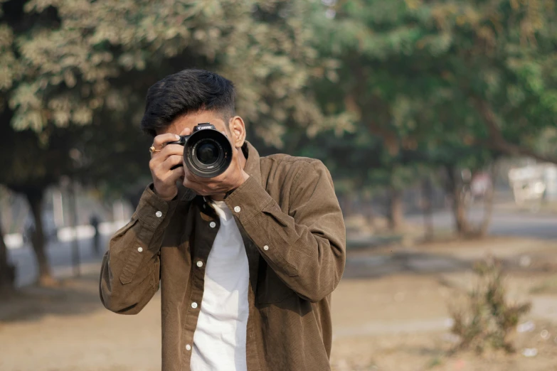 man taking po of himself with camera on street