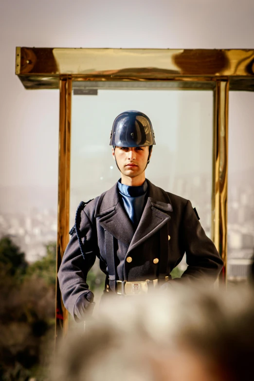 a man in a uniform stands by a mirror