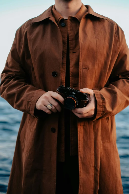 a man in a coat is holding a camera