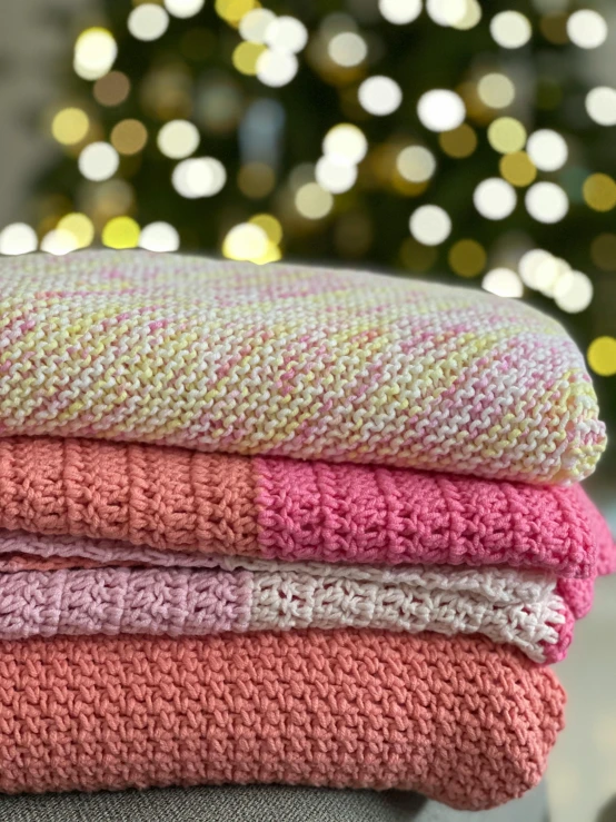 three knitted blankets stacked on top of each other