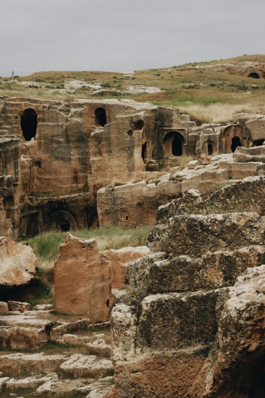 two giraffes standing in the middle of an ancient rocky area