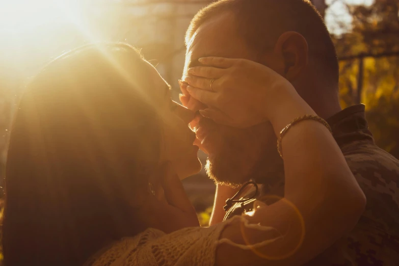 a couple is shown kissing in the sunlight