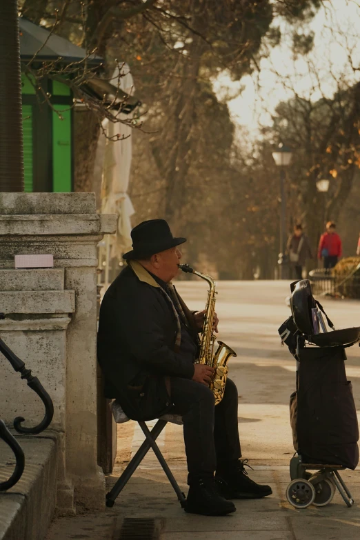 a man sits on a chair while playing the saxophone