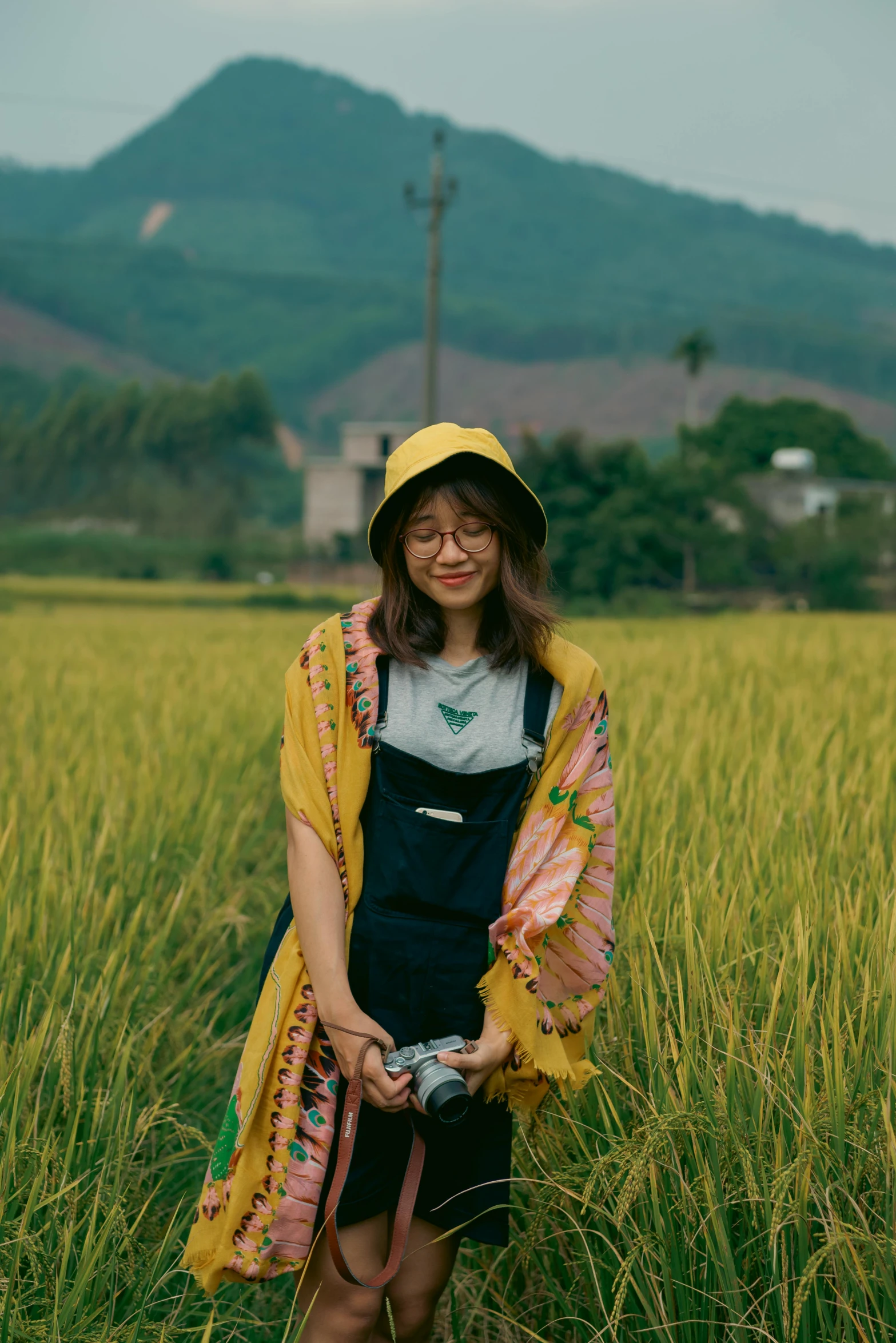 a young woman stands in a field with an umbrella over her head