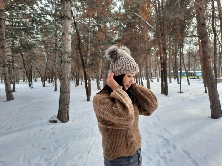 a woman is talking on her cell phone outside in the snow