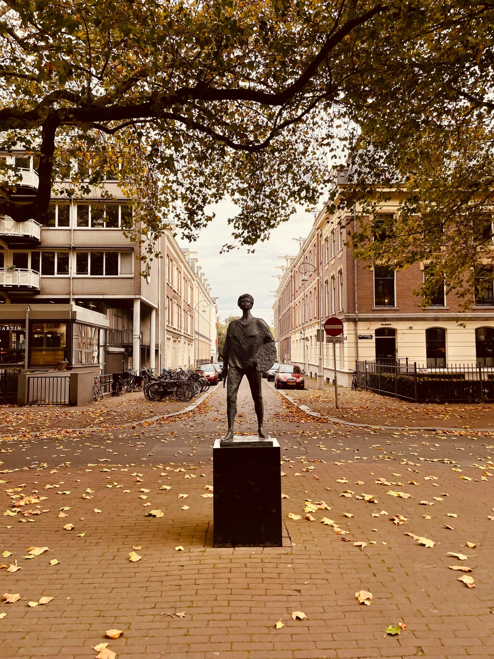 a statue of a man is in a yard surrounded by leaf